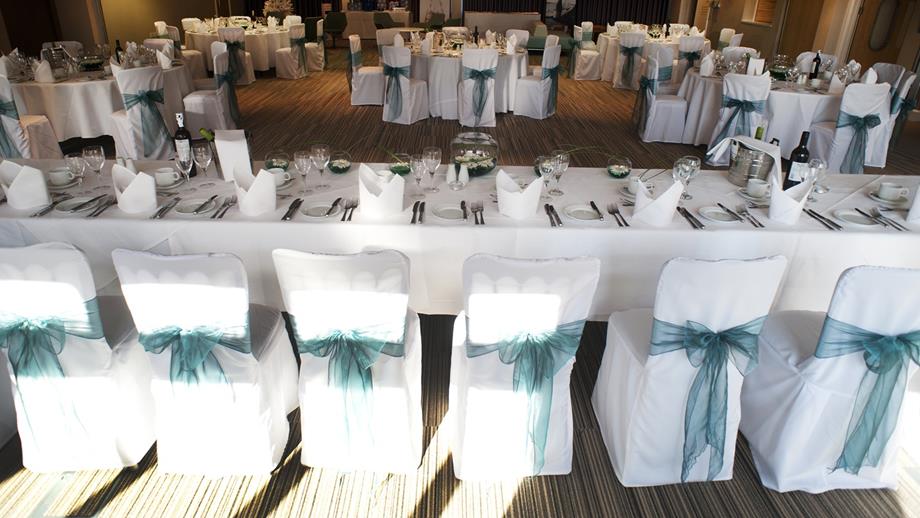 Dressed tables and chairs in the Waterfront Suite at the RNLI College, ready for an evening wedding celebration.